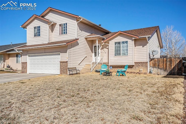 view of front of property with an attached garage, fence, brick siding, and driveway