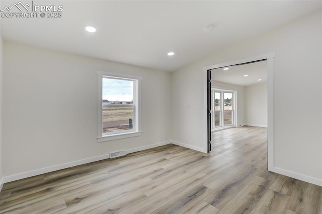 spare room featuring visible vents, recessed lighting, baseboards, and wood finished floors