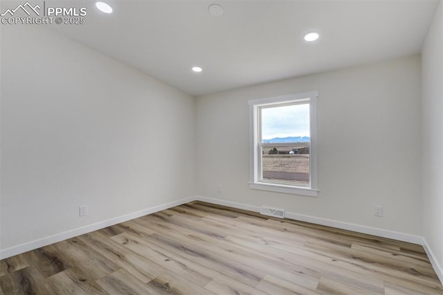 unfurnished room with recessed lighting, visible vents, baseboards, and wood finished floors