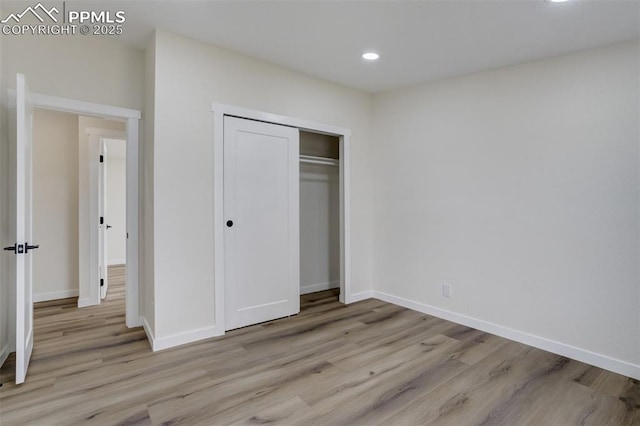 unfurnished bedroom with light wood finished floors, recessed lighting, a closet, and baseboards