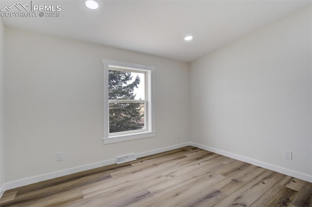 empty room with recessed lighting, visible vents, baseboards, and wood finished floors