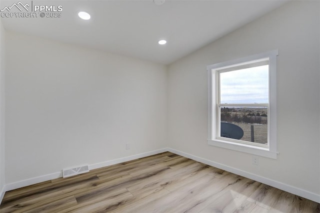 spare room with visible vents, recessed lighting, baseboards, and wood finished floors