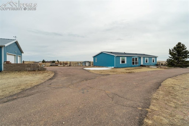 exterior space with a detached garage and fence