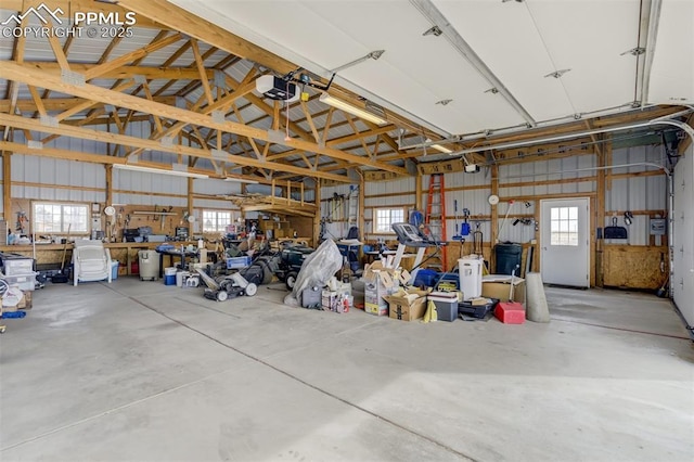 garage featuring metal wall, a workshop area, and a garage door opener