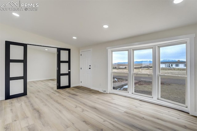 spare room with recessed lighting, light wood-style flooring, baseboards, and lofted ceiling