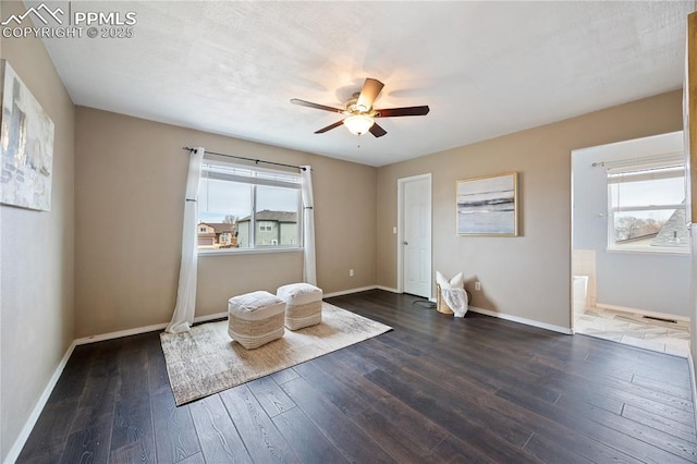 unfurnished room featuring dark wood-style floors, ceiling fan, and baseboards