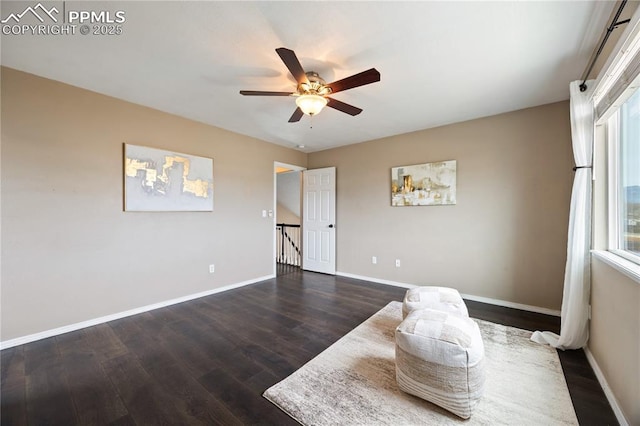 interior space with ceiling fan, baseboards, and wood finished floors