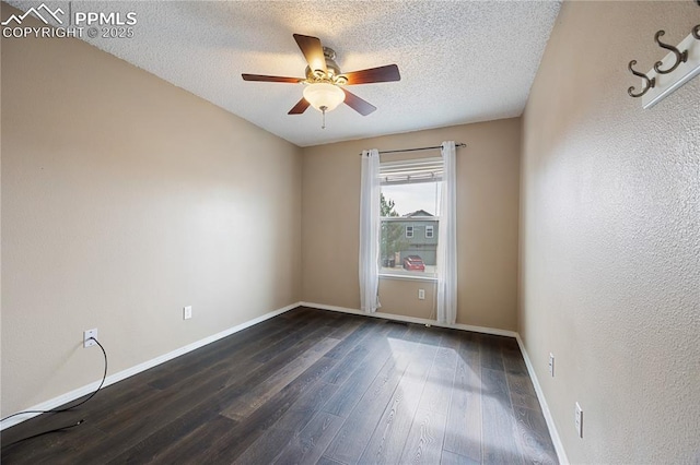 empty room featuring a textured wall, dark wood-type flooring, ceiling fan, a textured ceiling, and baseboards