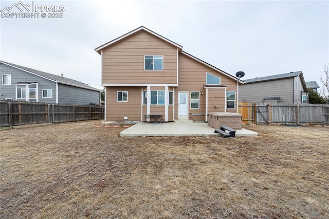 back of property with entry steps, a patio area, and a fenced backyard