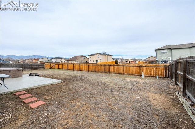 view of yard with a residential view, a fenced backyard, and a patio