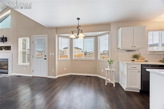 kitchen with dishwashing machine, a premium fireplace, light countertops, and white cabinets