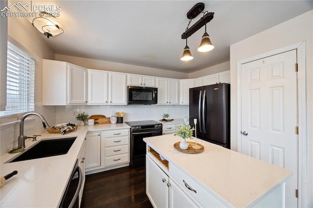 kitchen featuring black appliances, backsplash, a sink, and white cabinets