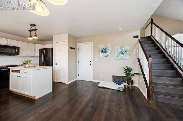 kitchen with black appliances, dark wood-type flooring, white cabinetry, and baseboards