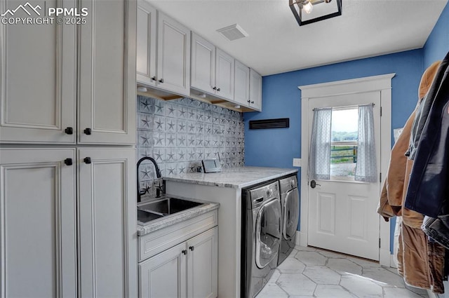 laundry area featuring visible vents, washing machine and dryer, a sink, and cabinet space