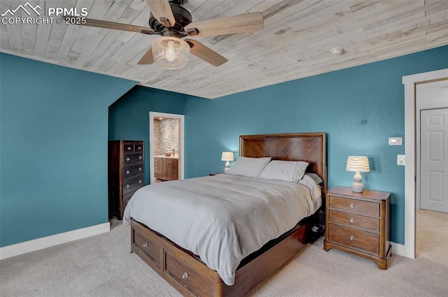 bedroom featuring ensuite bathroom, wooden ceiling, light colored carpet, a ceiling fan, and baseboards