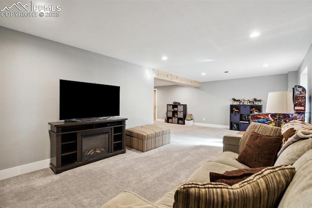 living room featuring carpet, a glass covered fireplace, baseboards, and recessed lighting