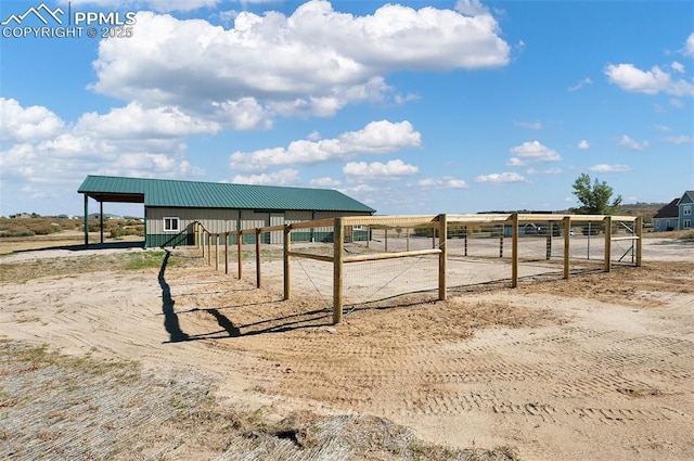 view of yard with a rural view, an outdoor structure, and an exterior structure