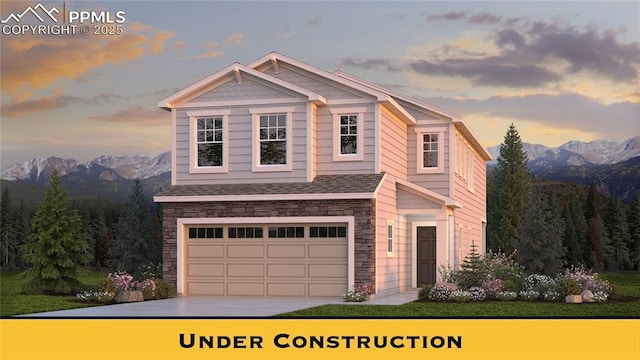 view of front of home featuring a mountain view, stone siding, and an attached garage