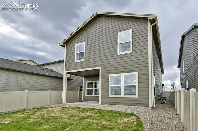 back of house featuring a patio, a lawn, and a fenced backyard