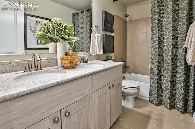 full bathroom with a sink, toilet, double vanity, and tile patterned flooring