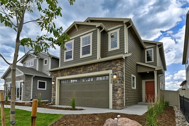 craftsman inspired home with stone siding, a garage, and fence