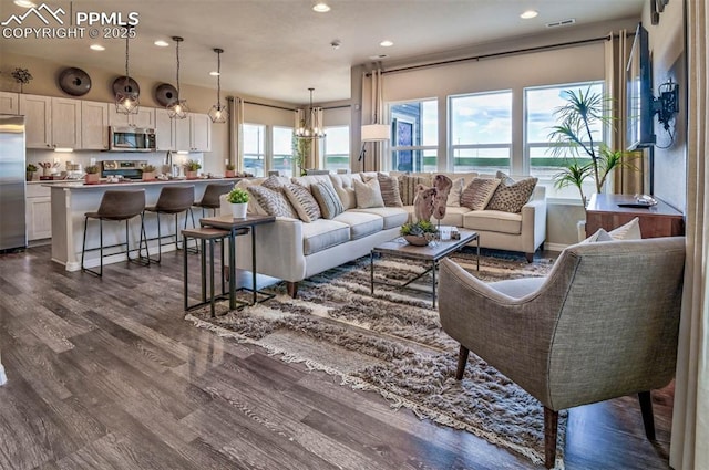 living room with recessed lighting, visible vents, an inviting chandelier, and dark wood-style floors