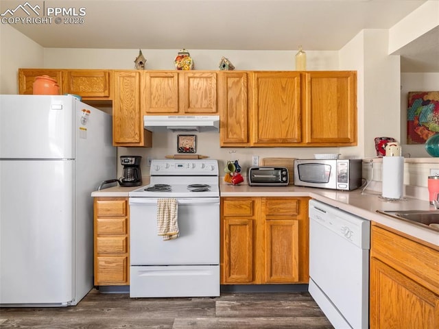 kitchen with dark wood-style floors, white appliances, light countertops, and under cabinet range hood