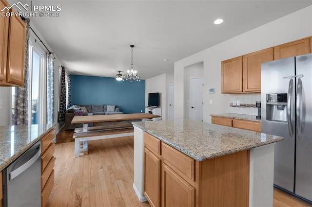 kitchen featuring light wood-type flooring, a center island, stainless steel appliances, and open floor plan