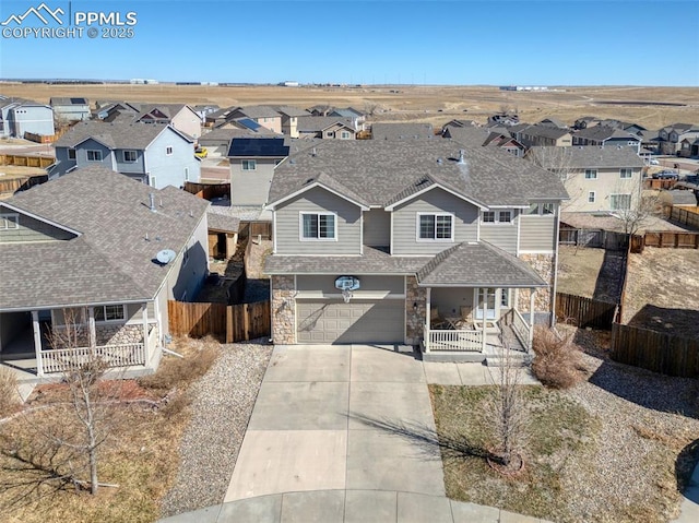 view of front of property featuring stone siding, a residential view, fence, and a porch