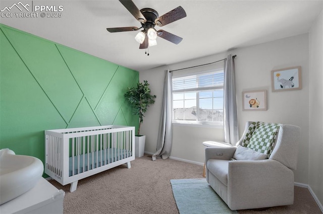 bedroom with a ceiling fan, carpet, a crib, and baseboards