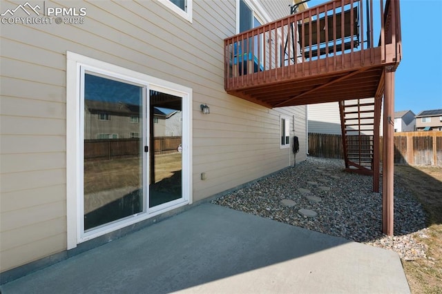 view of patio / terrace featuring fence and stairway