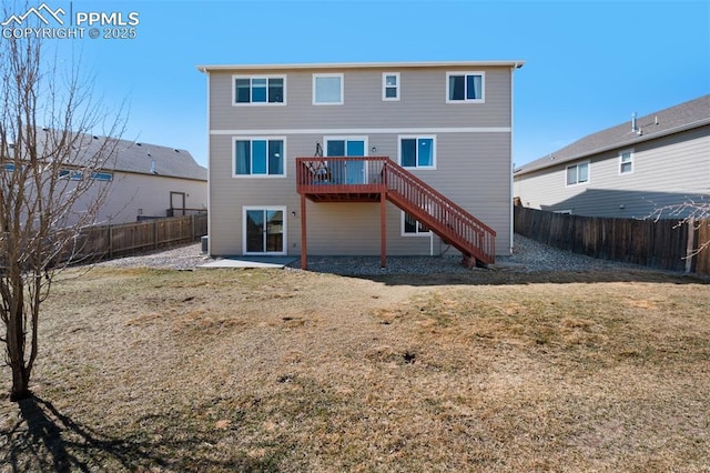 back of property with a fenced backyard, a lawn, a wooden deck, and stairs