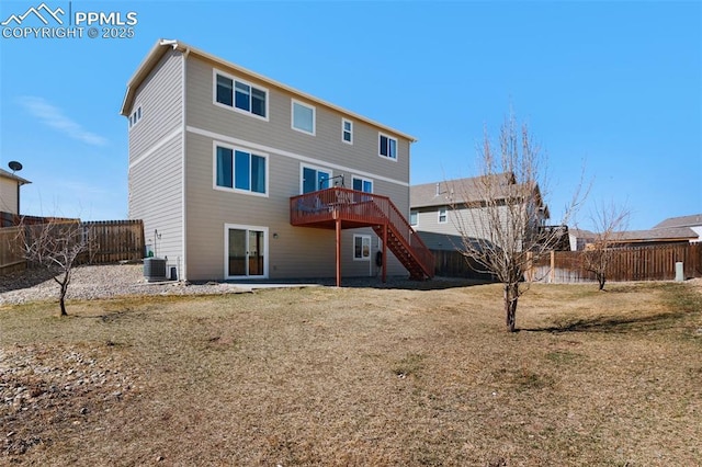 rear view of property with central AC unit, a lawn, a fenced backyard, stairway, and a deck