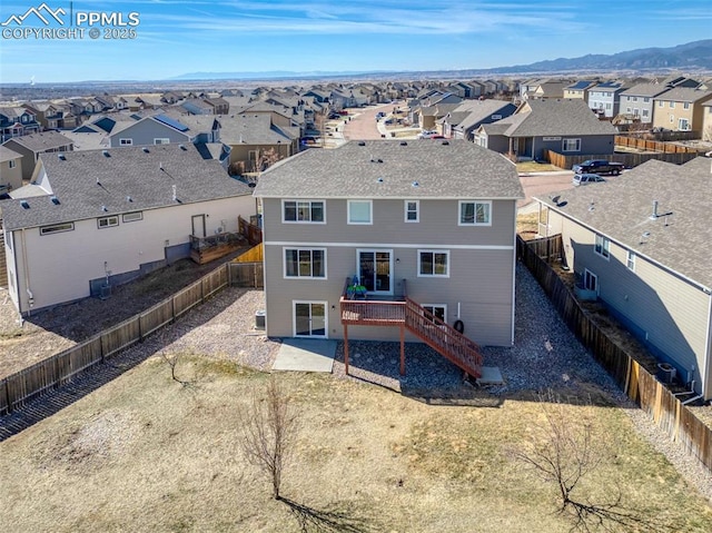 rear view of property featuring a fenced backyard, a residential view, stairway, cooling unit, and a mountain view