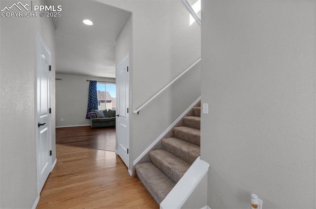 stairway featuring baseboards and wood finished floors