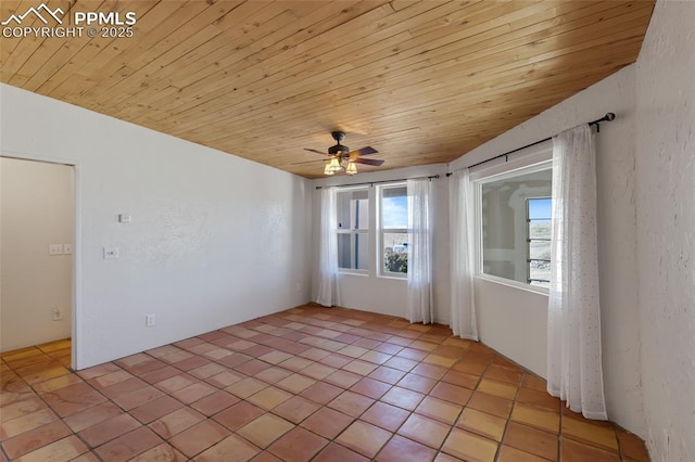 empty room with a textured wall, wood ceiling, ceiling fan, and light tile patterned flooring