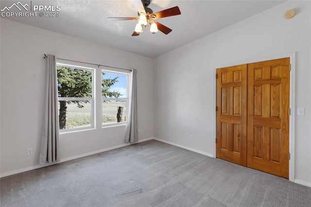 empty room featuring a ceiling fan, baseboards, and carpet flooring