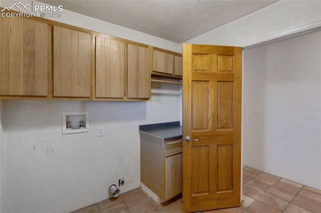 laundry area featuring cabinet space, light tile patterned floors, hookup for a washing machine, a textured ceiling, and electric dryer hookup