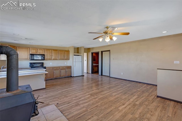 kitchen with baseboards, a ceiling fan, light wood-style flooring, light countertops, and black appliances