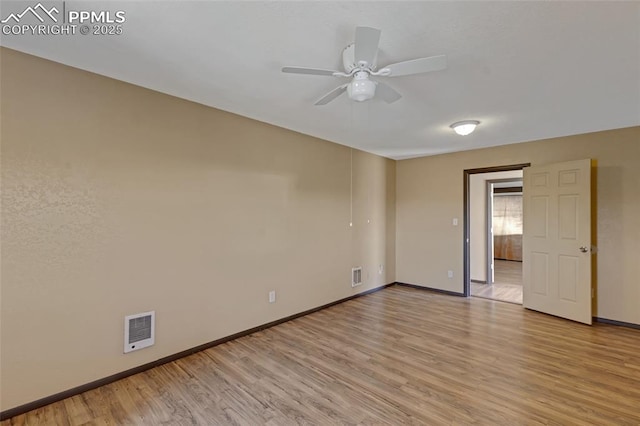 empty room with a ceiling fan, baseboards, visible vents, and light wood finished floors