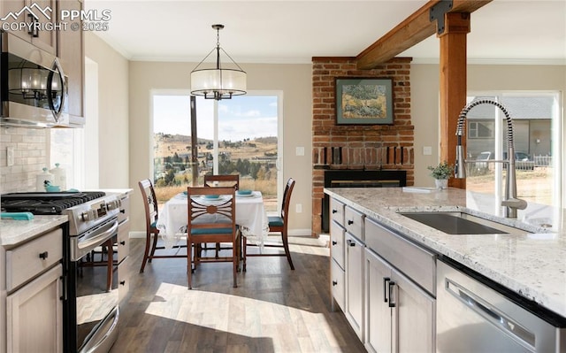 kitchen with tasteful backsplash, dark wood-type flooring, stainless steel appliances, crown molding, and a sink