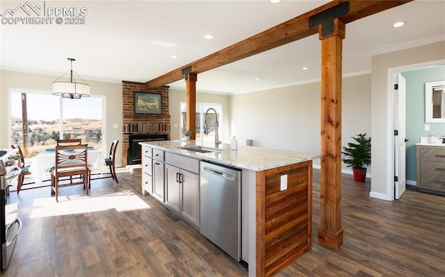 kitchen with appliances with stainless steel finishes, beamed ceiling, plenty of natural light, and a sink