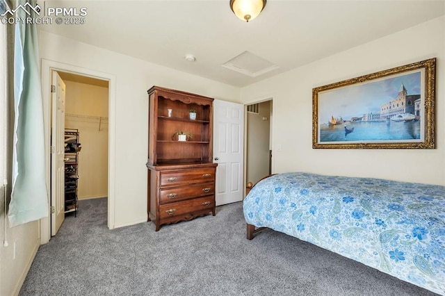 bedroom featuring a spacious closet, carpet flooring, and attic access