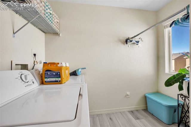 laundry area with baseboards, laundry area, washer and clothes dryer, and light wood-style floors