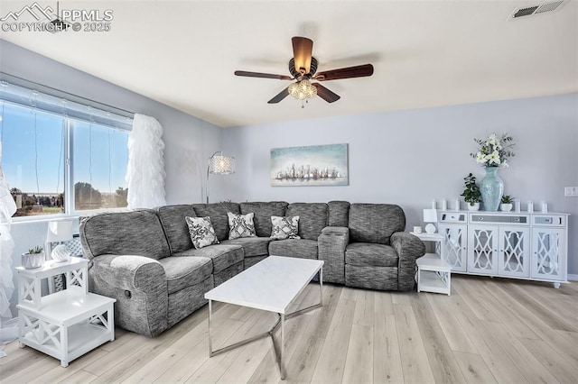 living room featuring a ceiling fan, visible vents, and wood finished floors