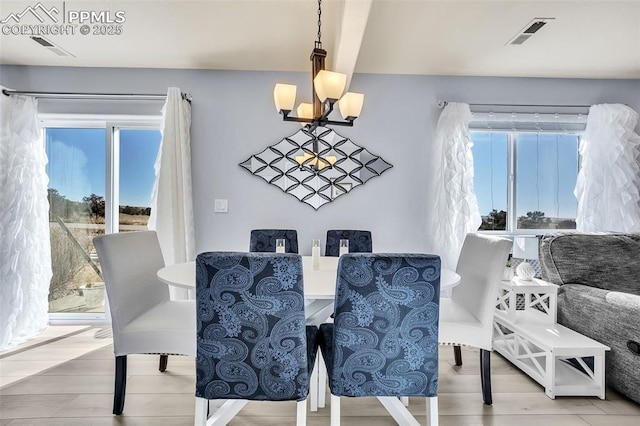 dining space featuring a wealth of natural light, visible vents, and a notable chandelier