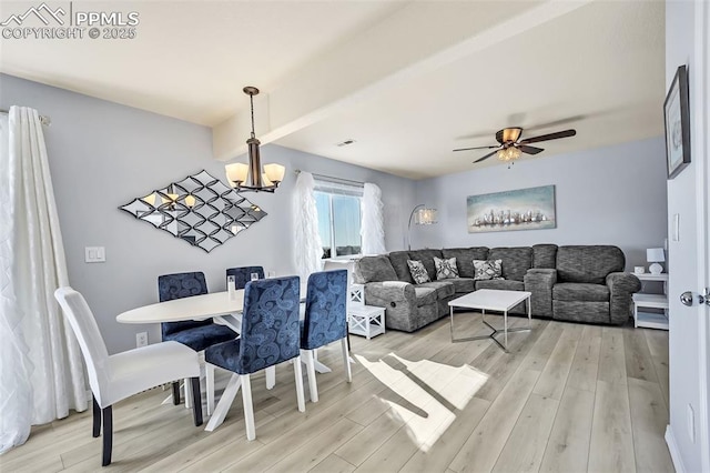 dining room featuring light wood finished floors, visible vents, and ceiling fan with notable chandelier