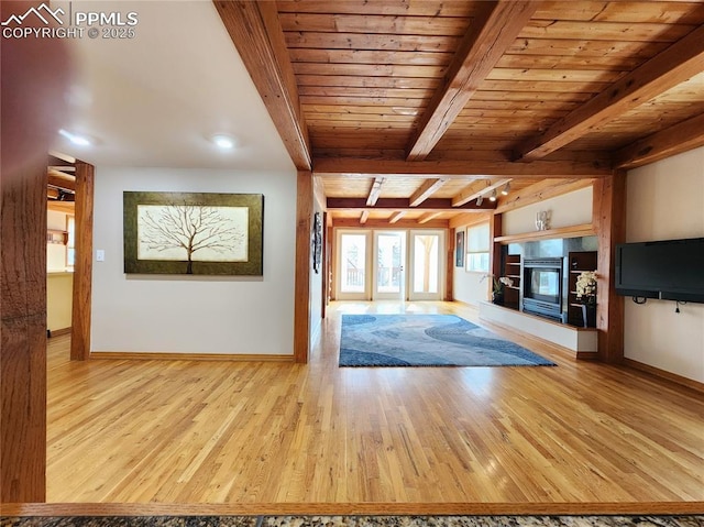 unfurnished living room featuring baseboards, beamed ceiling, wood ceiling, wood finished floors, and a glass covered fireplace