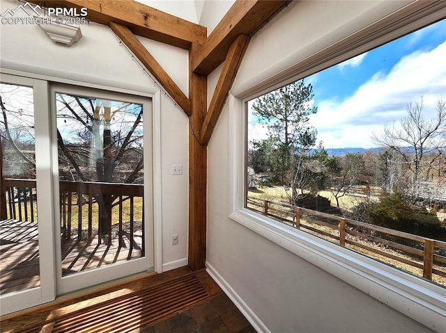 entryway featuring a wealth of natural light, brick floor, and baseboards