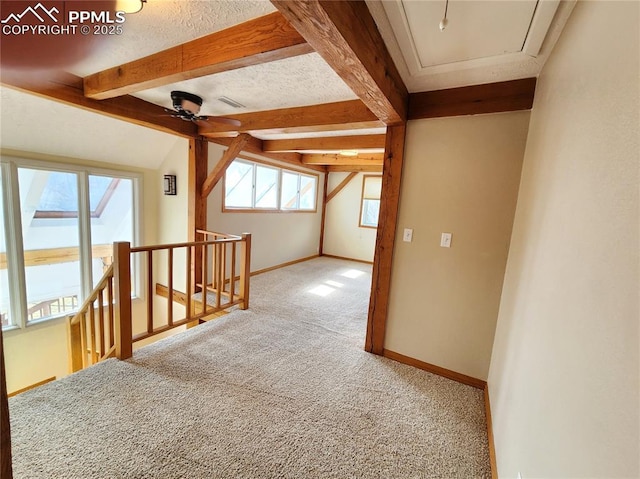 hall with an upstairs landing, attic access, baseboards, and carpet floors